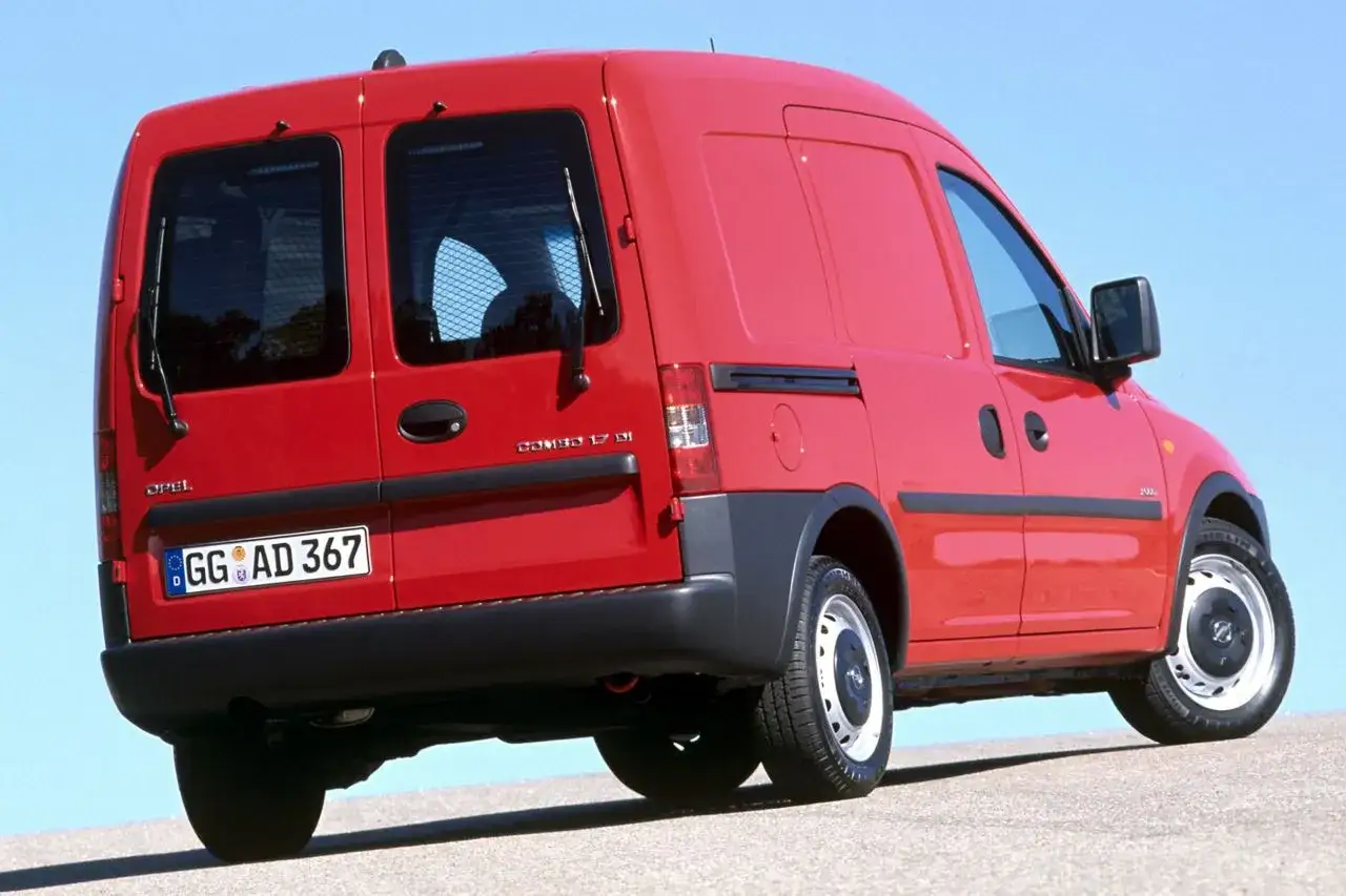 Czerwony Opel Combo C z przyciemnianymi tylnymi drzwiami i kratką ochronną.