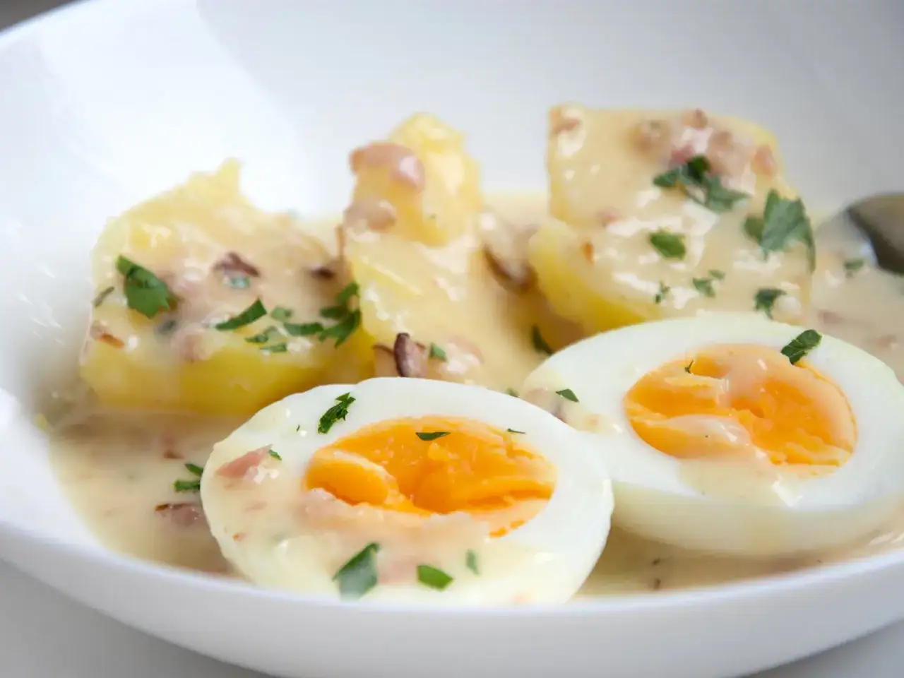 Eier in Senfsauce, ein leckeres Rezept von Mutti, serviert mit Kartoffeln und Petersilie.