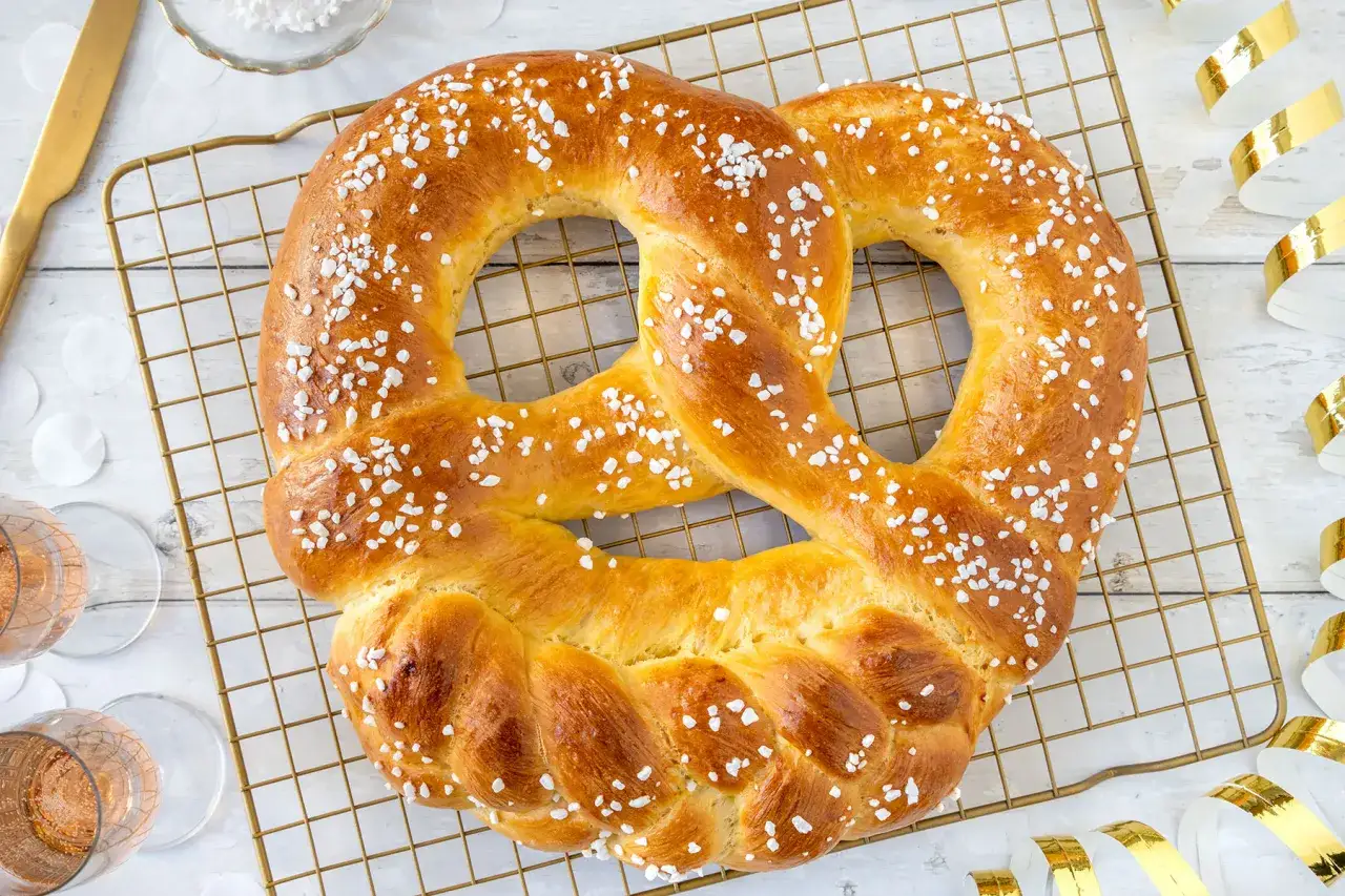 Goldbraune Neujahrsbrezel mit Hagelzucker auf einem Gitter. Ein köstliches Rezept für Silvester!