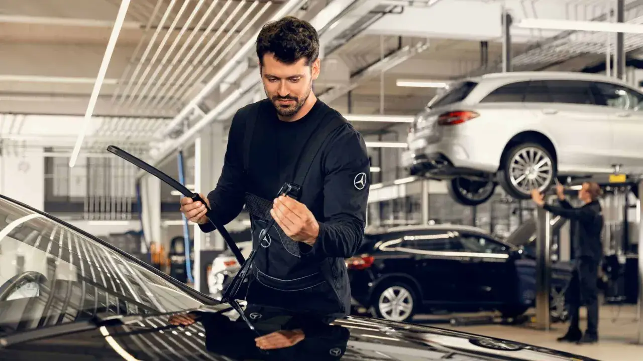 Mechaniker prüft Scheibenwischer. Informieren Sie sich über die **Service B Mercedes Kosten** und halten Sie Ihren Stern in Topform.