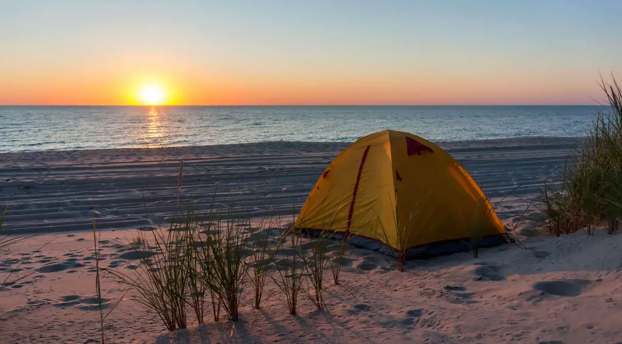 Ż&oacute;łty namiot na plaży o zachodzie słońca. Idealne miejsce, gdzie pod namiot można uciec od zgiełku.