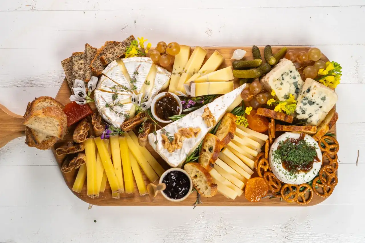Tabla de quesos variados, panes, frutos secos y uvas. Un fest&iacute;n que muestra qu&eacute; comen los franceses.