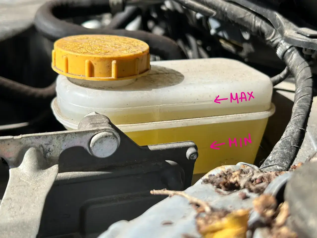 Réservoir de liquide de frein jaune, avec repères MAX et MIN. Vérifiez le niveau pour savoir quand changer liquide de frein.