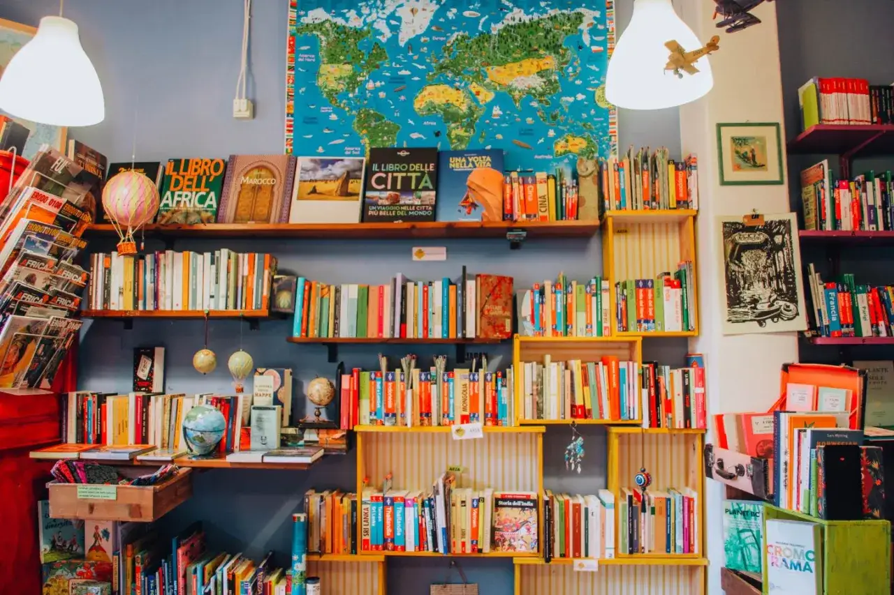 Scaffali pieni di libri avvincenti, un mappamondo e mongolfiere decorative creano un'atmosfera da libreria da sogno.