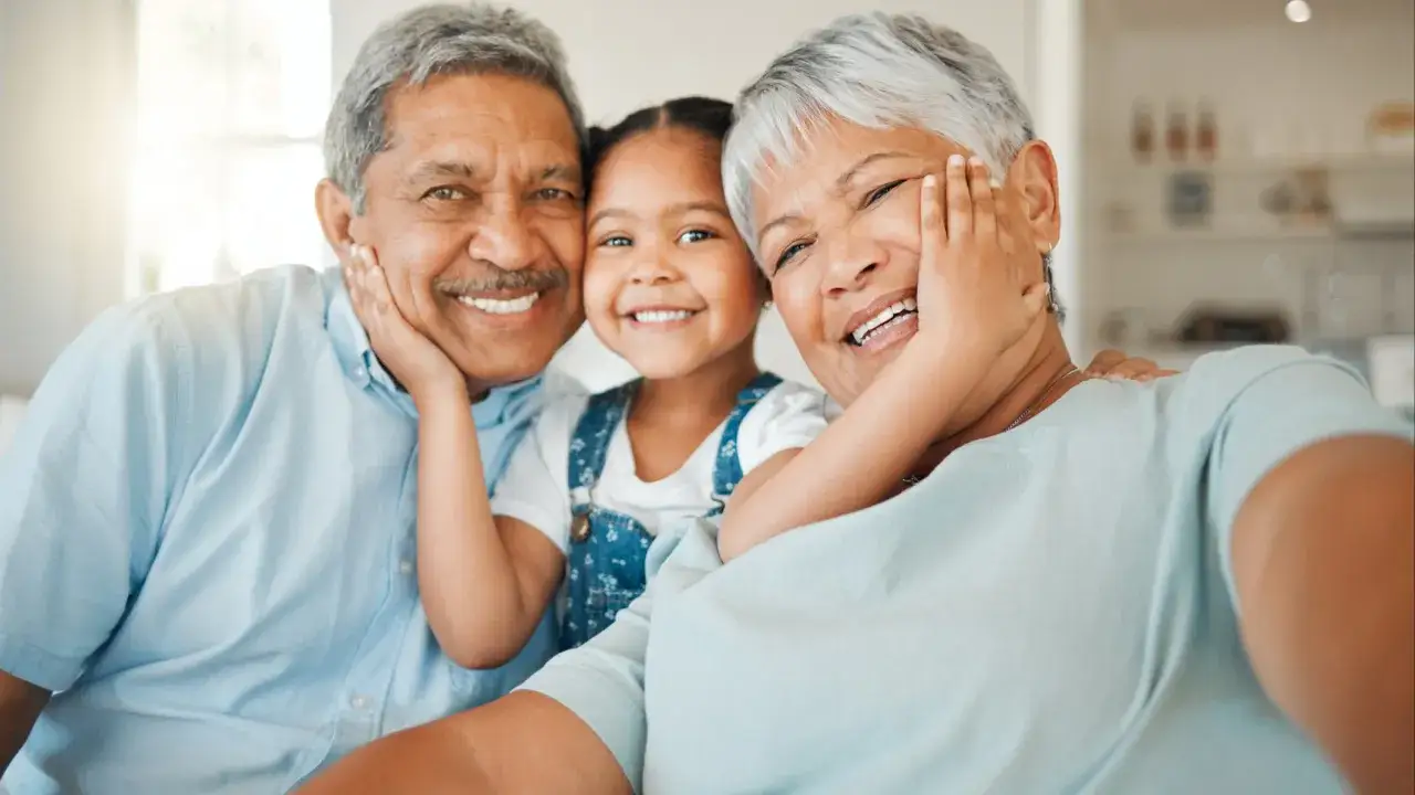 Abuelos sonriendo con su nieta. Los padres confían en ellos para cuidar a sus hijos.