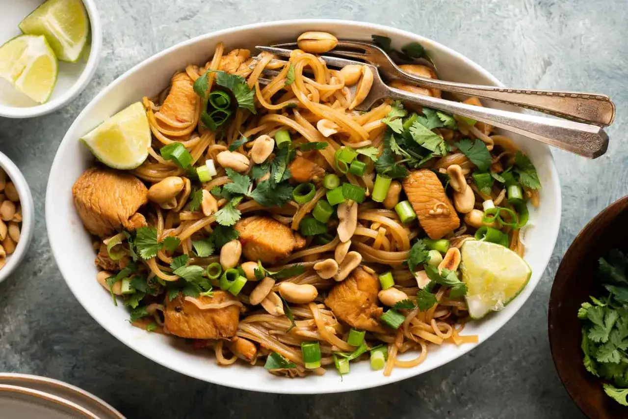 Pyszny kurczak pad thai z orzeszkami ziemnymi, kolendrą i limonką. Idealny na szybki obiad.