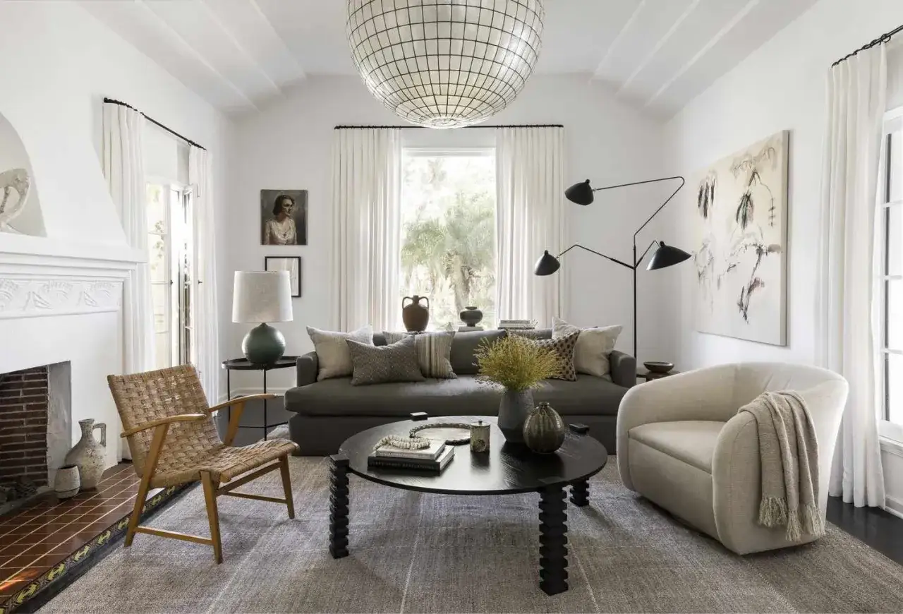 Nowoczesny salon z wygodną kanapą, fotelem i stolikiem kawowym. Stylowe meble po angielsku, duża lampa i obraz na ścianie tworzą przytulną atmosferę.