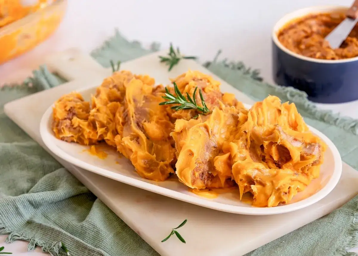 Delicioso lomo en manteca, servido en plato blanco con romero. Un manjar para disfrutar.