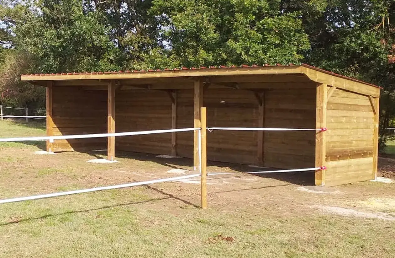 Abri chevaux en bois, idéal pour le pâturage, sans permis de construire. Il offre un abri simple et fonctionnel pour vos équidés.