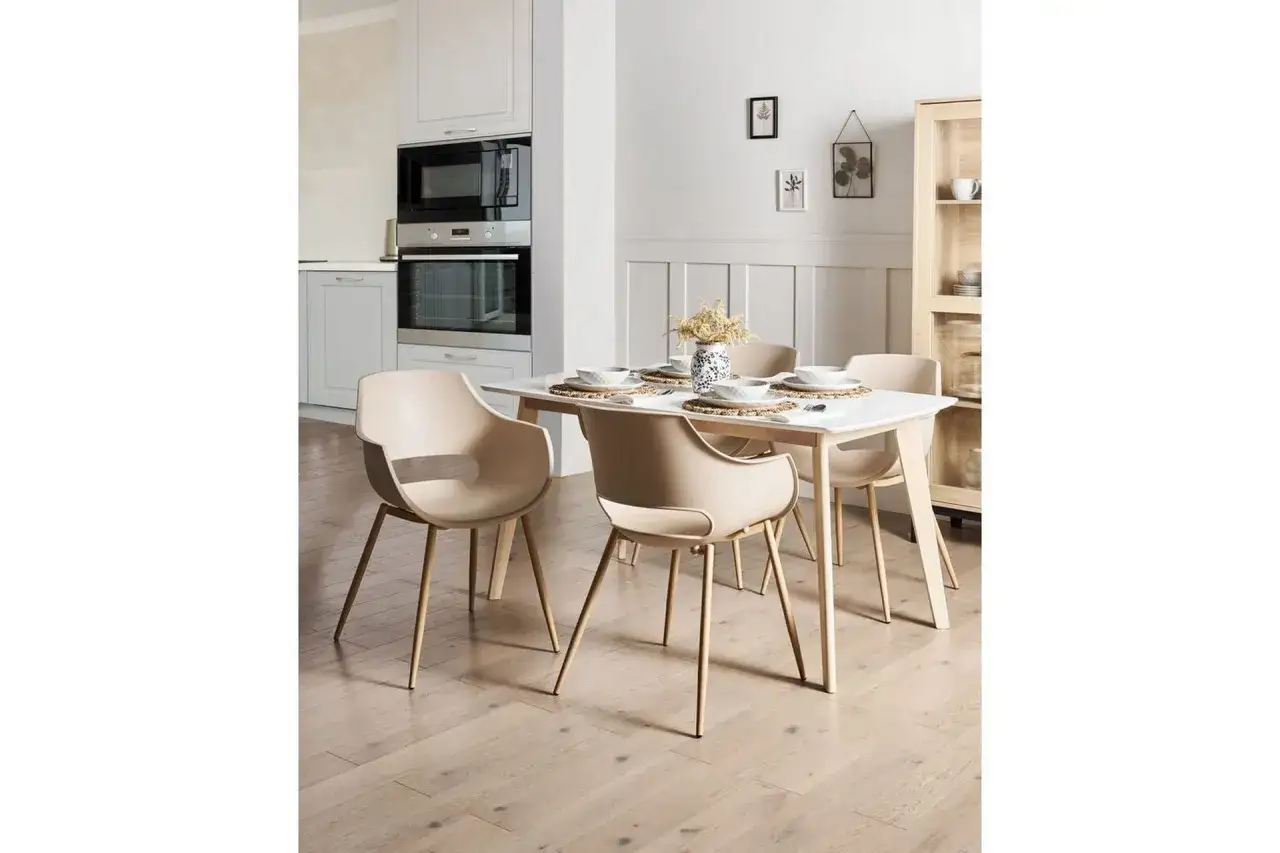 Modern matsal inspiration med ljusa stolar och ett dukat bord. Köksinredning syns i bakgrunden.
