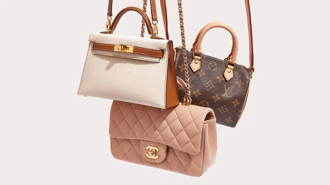 Trzy ikoniczne, luksusowe marki torebek: kremowa Hermès, różowa Chanel i brązowa Louis Vuitton, prezentują swoje klasyczne modele.