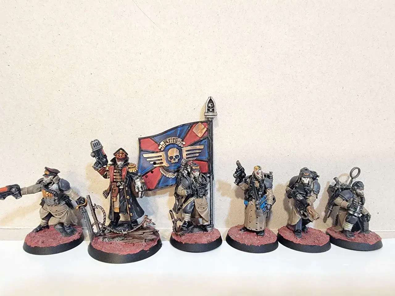 Sześciu żołnierzy z krieg command squad, z oficerem niosącym sztandar, gotowych do walki.