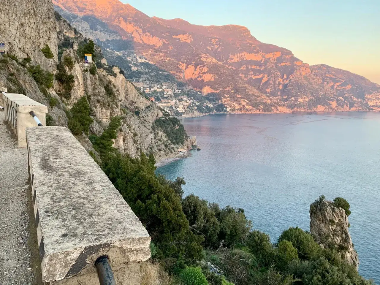 A steep, winding road hugs the cliffside overlooking the sea. The path of the gods is dangerous, with sheer drops and narrow passages, but the views are breathtaking.