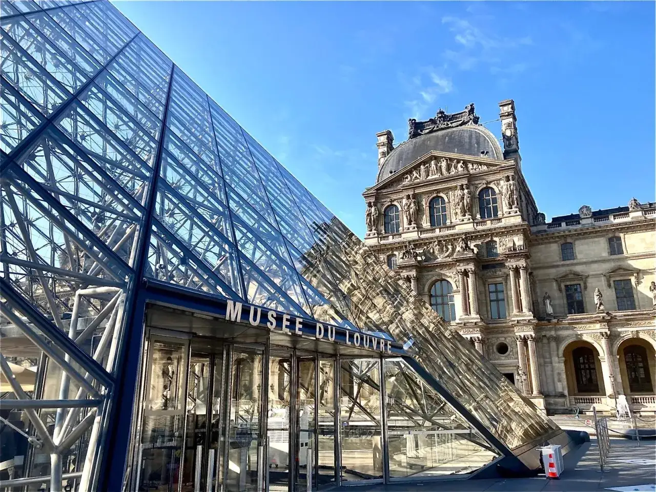 Glaspyramiden vid museet i Paris reflekterar den klassiska arkitekturen.