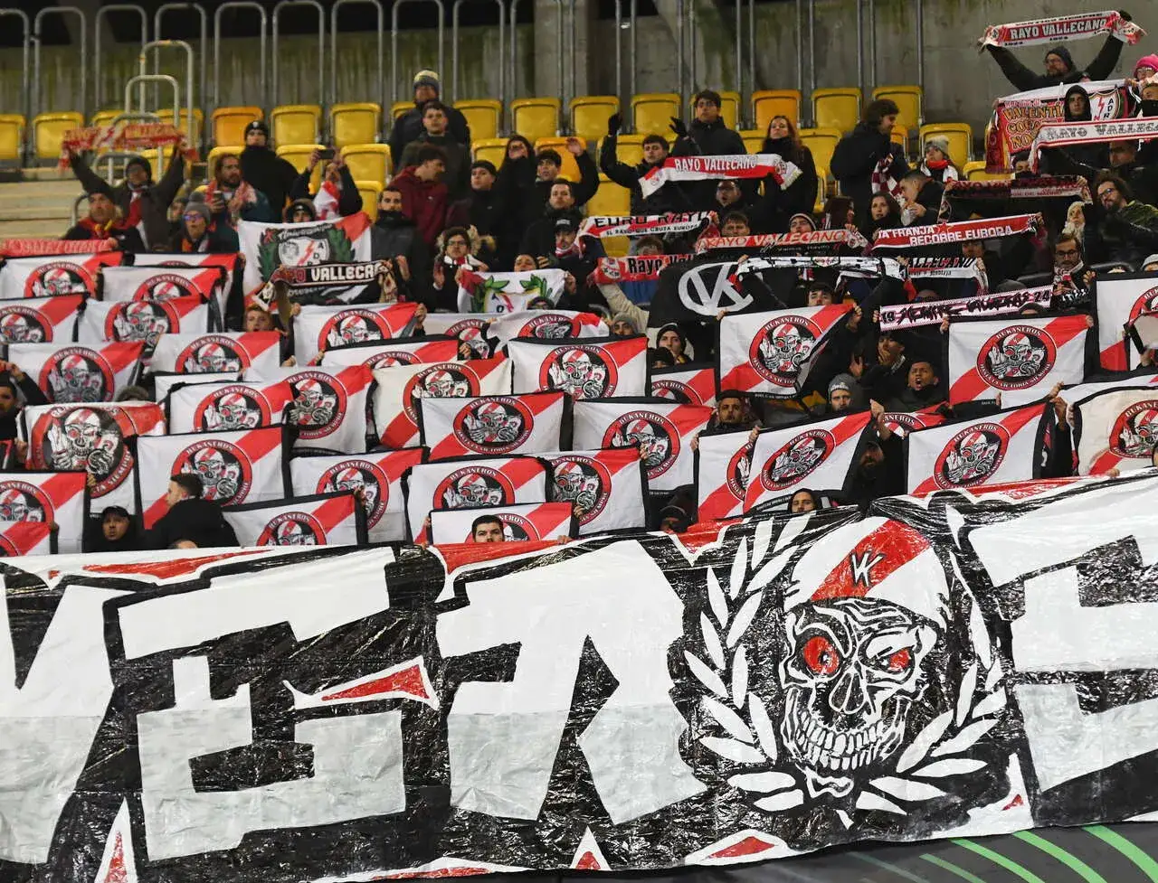 Fani Rayo Vallecano z szalikami i flagami z czaszką. Stadion wypełniony kibicami wspierającymi drużynę z Vallecas.