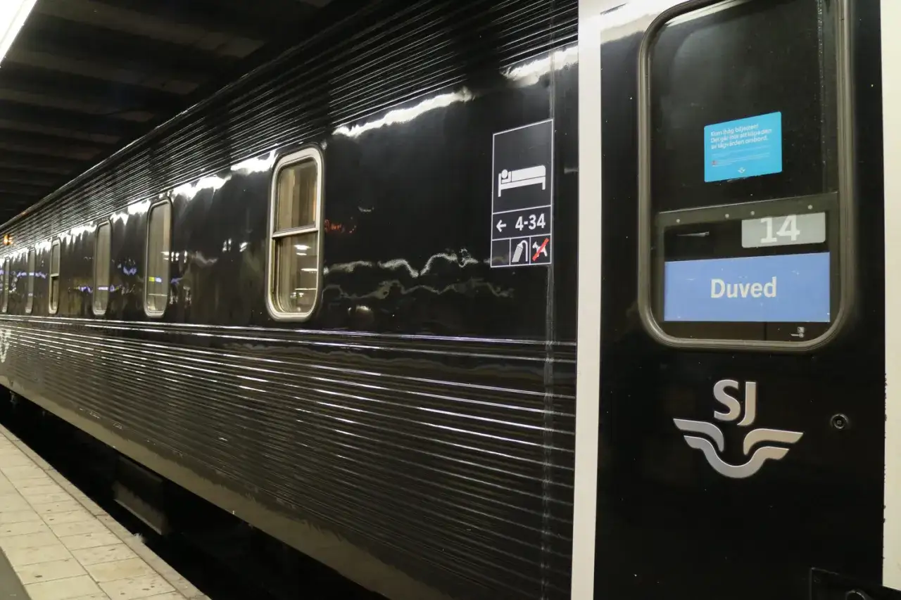 Svart nattåg med SJ-logotypen. Vagn 14, Duved, är redo för resan. Snart avgår nattåg till Stockholm.