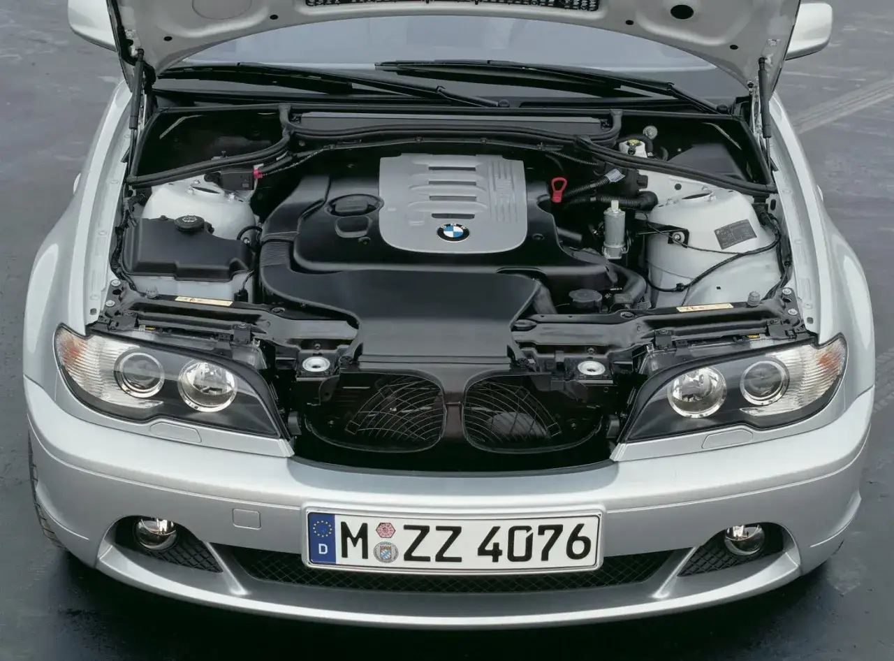 Srebrne e46 BMW z otwartą maską, widoczny silnik i przednie reflektory.