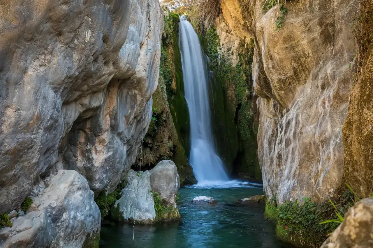 Cascada cayendo en pozas cristalinas, un rincón idílico de piscinas naturales Alicante.