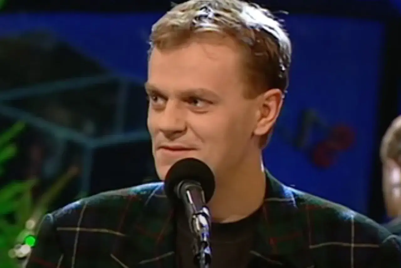 Młody Donald Tusk w kratce, tuż przed tym, kiedy urodził się Donald Tusk, uśmiecha się do mikrofonu.