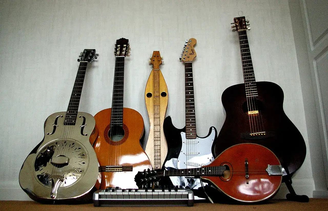 Kto wynalazł gitarę? Na zdjęciu różne instrumenty strunowe: gitara rezofoniczna, klasyczna, elektryczna, mandolina i inne.