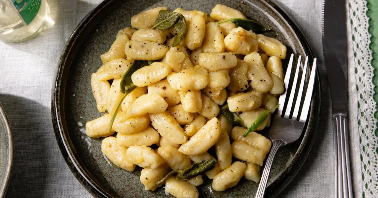 Gnocchi maison dorés et savoureux, parsemés de feuilles de sauge fraîche. Un plat réconfortant prêt à être dégusté.