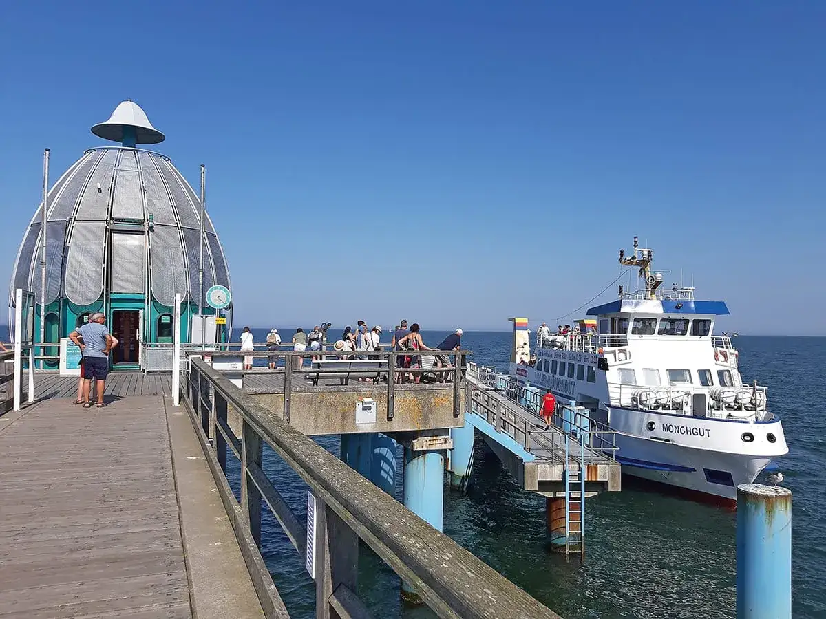 Menschen auf einem Pier in Sassnitz an der Ostsee, ein Schiff namens