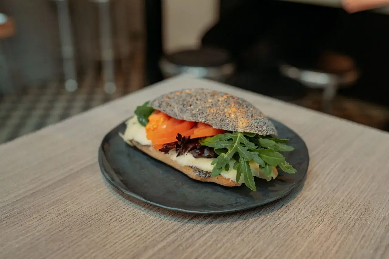 En h&auml;rlig macka med sallad, tomat och ost p&aring; ett m&ouml;rkt br&ouml;d med vallmofr&ouml;n. Perfekt f&ouml;r en god lunch.