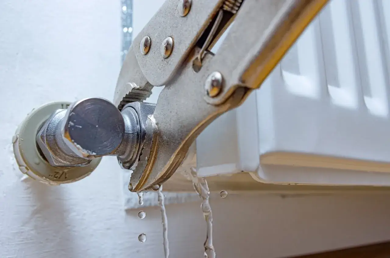 Herramienta sujetando una conexi&oacute;n de radiador que gotea. Se est&aacute; intentando cambiar la llave radiador que gotea.