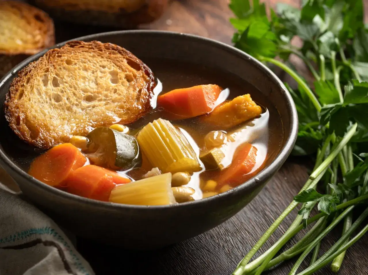 Varm kycklingsoppa med rotfrukter och en rostad brödskiva. Ett perfekt kycklingsoppa recept för kalla dagar.
