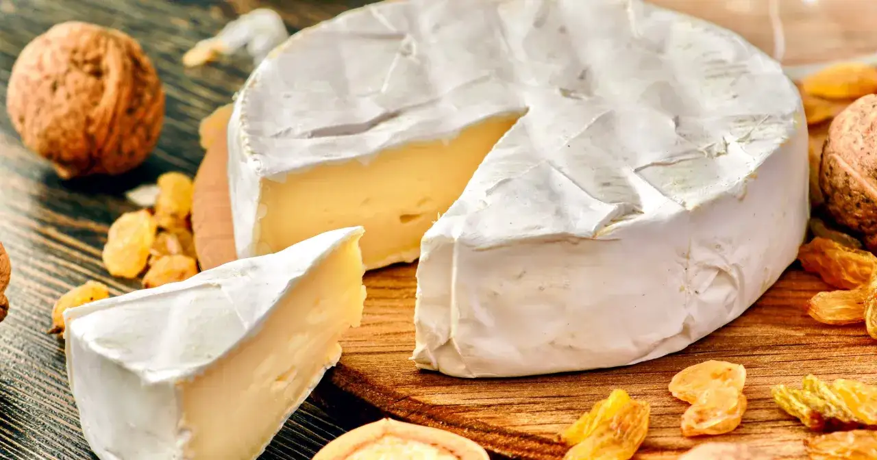 Pyszny camembert z białą pleśnią, z kawałkiem odciętym dla spróbowania. Zastanawiasz się, ile kalorii ma camembert?