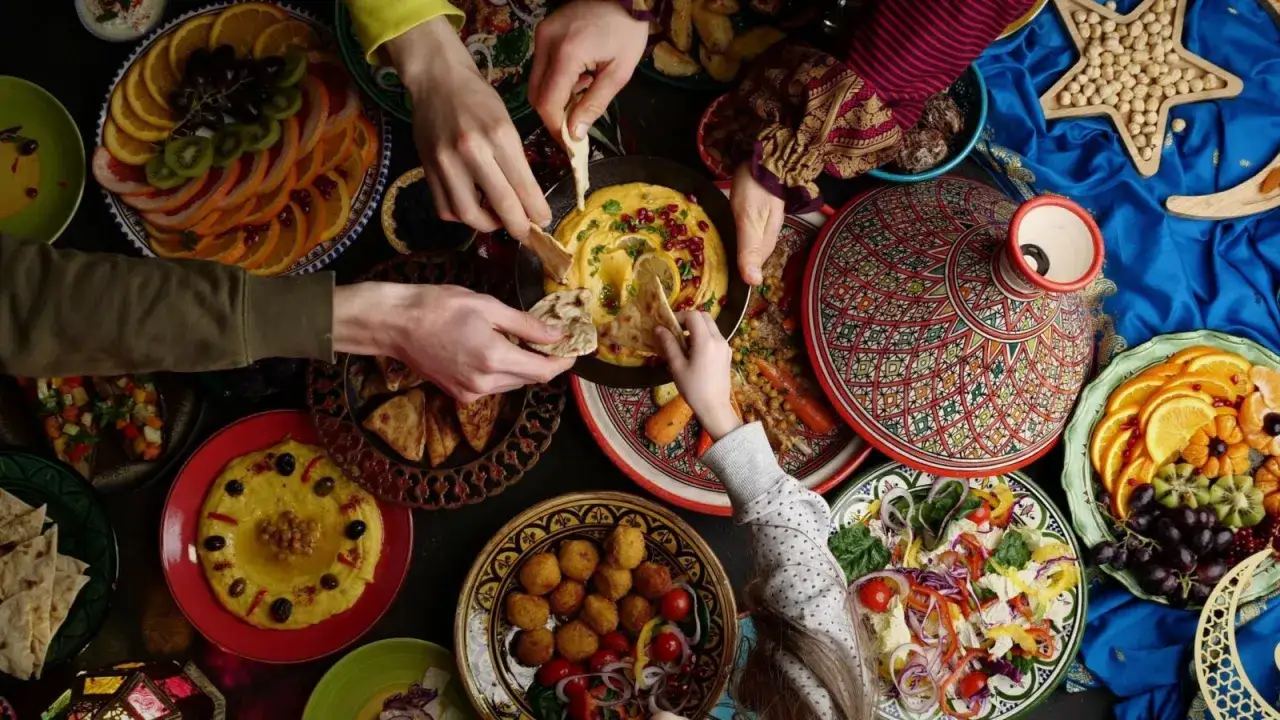 Familie teilt sich köstliches arabisches Essen: Hummus, Falafel, Obst und mehr.