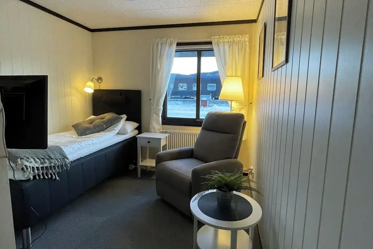 Mysigt rum p&aring; vandrarhem i &Aring;re. Enkels&auml;ng, f&aring;t&ouml;lj och f&ouml;nster med utsikt.