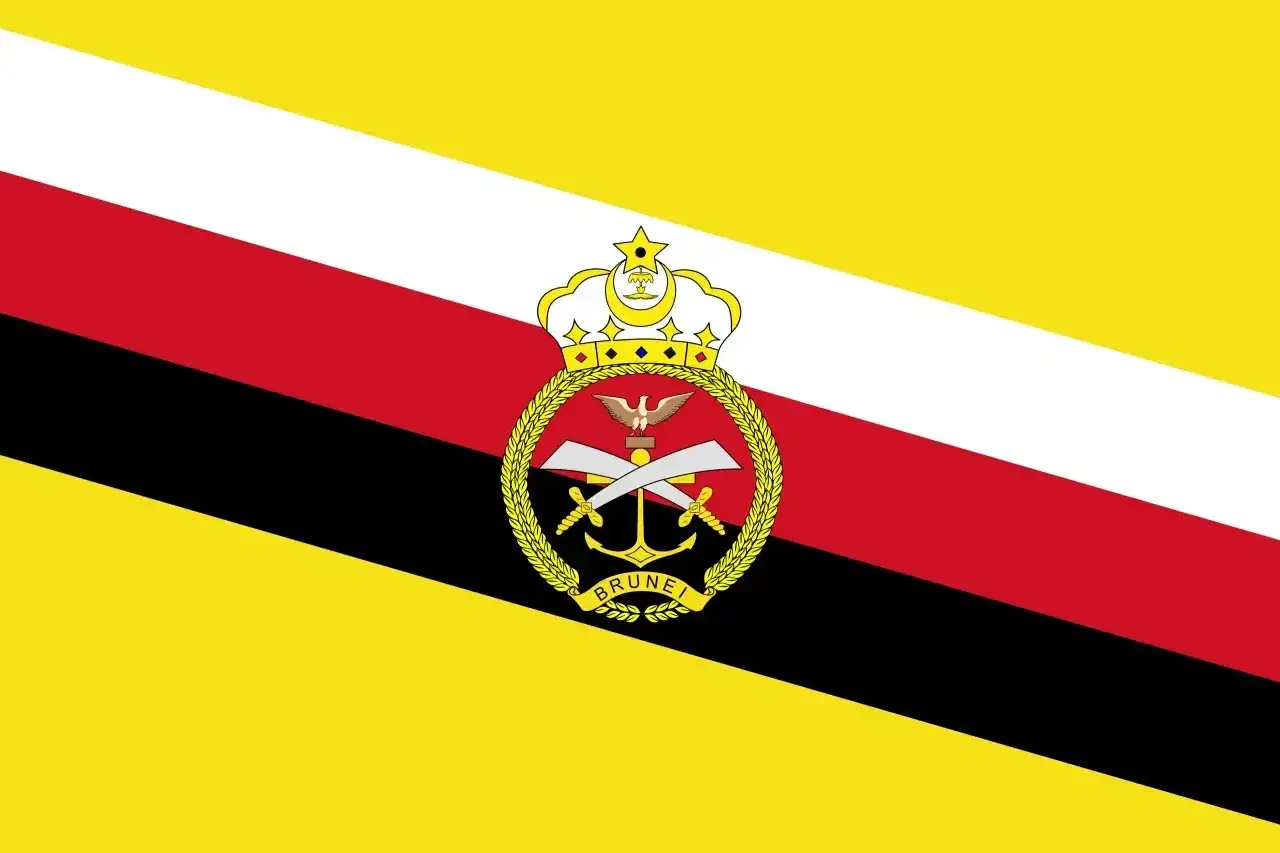 Flaga Brunei z herbem: żółte, białe, czerwone i czarne pasy ukośne, na środku korona, skrzydła, dwa skrzyżowane miecze, kotwica i napis 