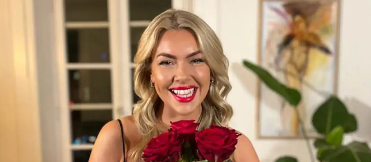 Sonja Livbom ler glatt med röda rosor i famnen.