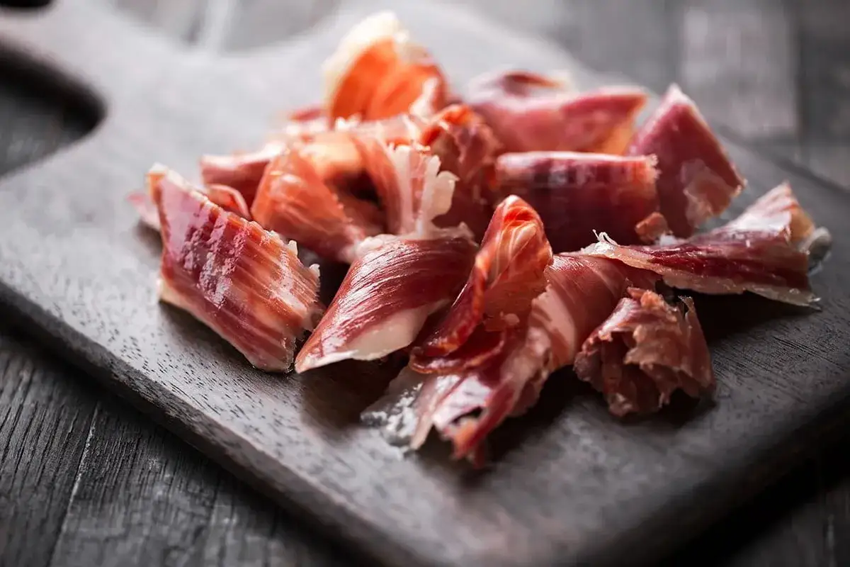 Kawałki hiszpańskiej szynki serrano na desce. Idealny pomysł, co przywieźć z Hiszpanii.