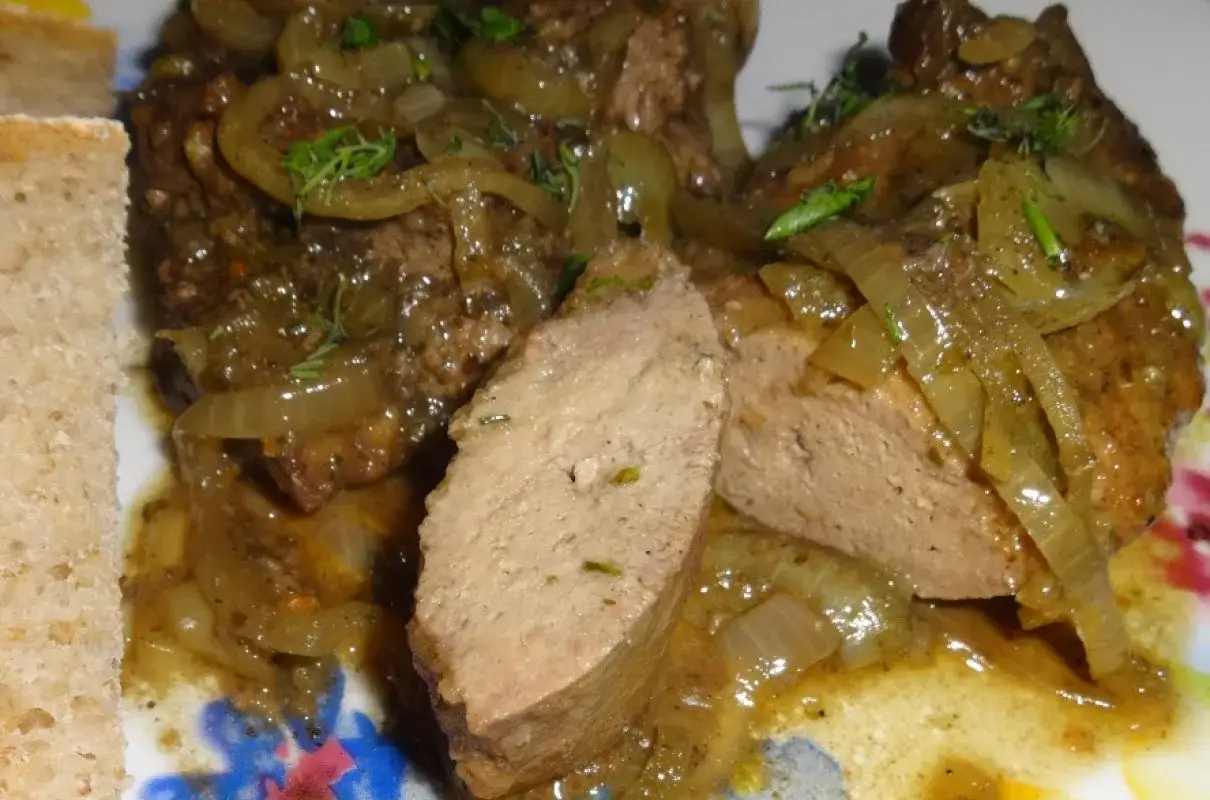 Pyszna wątróbka w sosie z cebulką, podana z chlebem. Aromatyczne danie, które rozpływa się w ustach.