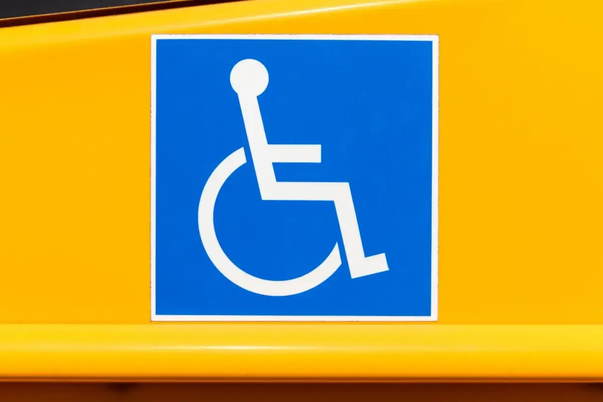 Simbolo di accessibilit&agrave; per disabili su sfondo giallo, conforme alla legge 67/2006.