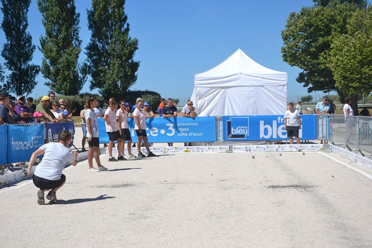Joueurs de pétanque en compétition, sous le soleil. On se demande combien gagne un joueur de pétanque professionnel pour un tel spectacle.
