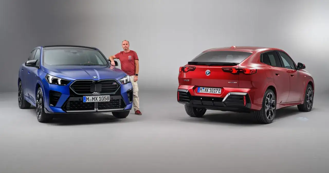 Dwa BMW X2: jeden niebieski, drugi czerwony, stoją obok siebie. Mężczyzna opiera się o niebieski samochód.