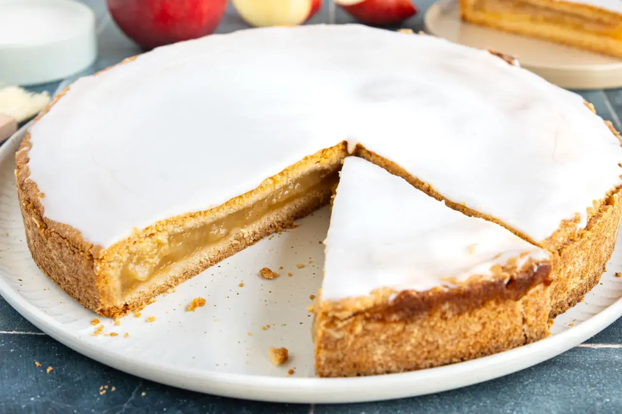 Ein köstlicher Apfelkuchen mit einer zarten Apfelmusfüllung, überzogen mit süßem Zuckerguss.
