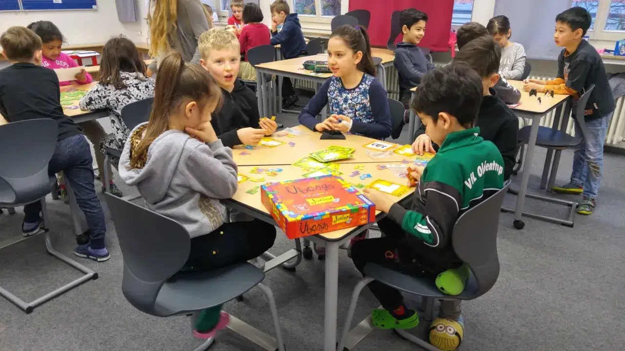 Kinder spielen konzentriert das Spiel Ubongo Junior. Diese **Bewegungsspiele** fördern das logische Denken und die Feinmotorik.
