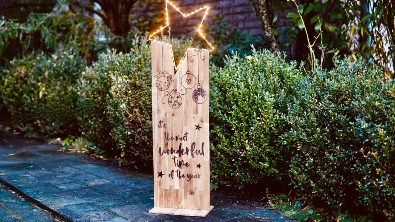 Selbstgemachte weihnachtsdeko aussen: Ein Holzschild mit Stern und Weihnachtskugeln, das 