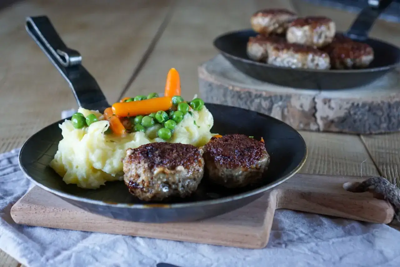 Herzhafte Frikadellen mit Kartoffelbrei, Erbsen und Möhren. Ein klassisches Frikadellen Rezept für ein deftiges Essen.