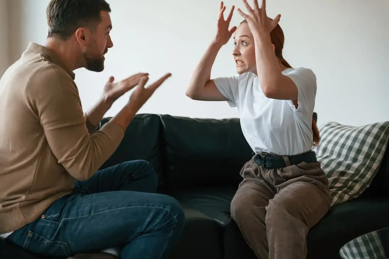 Un couple en pleine dispute, illustrant un **probl&egrave;me de communication psychologie**. Les gestes et expressions montrent une tension palpable.