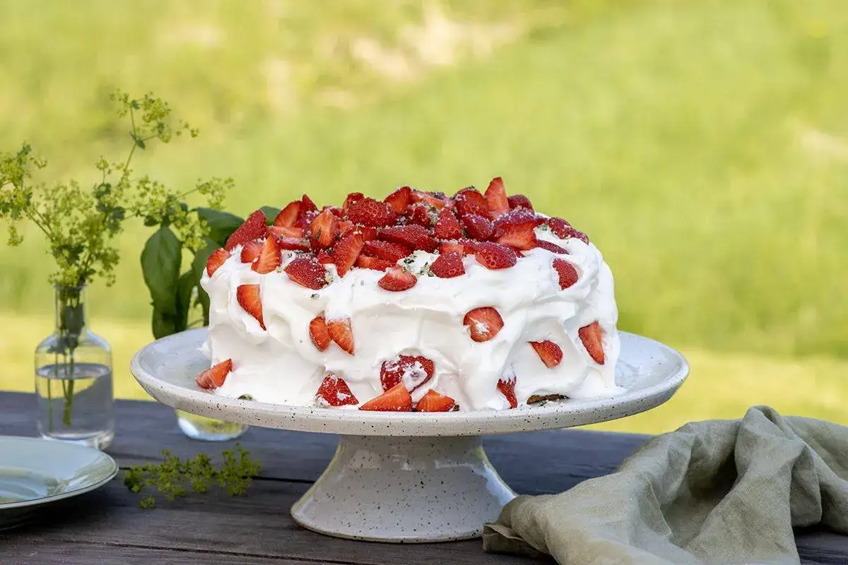 En h&auml;rlig t&aring;rta med fluffig gr&auml;dde och massor av f&auml;rska jordgubbar, perfekt f&ouml;r en sommardag.