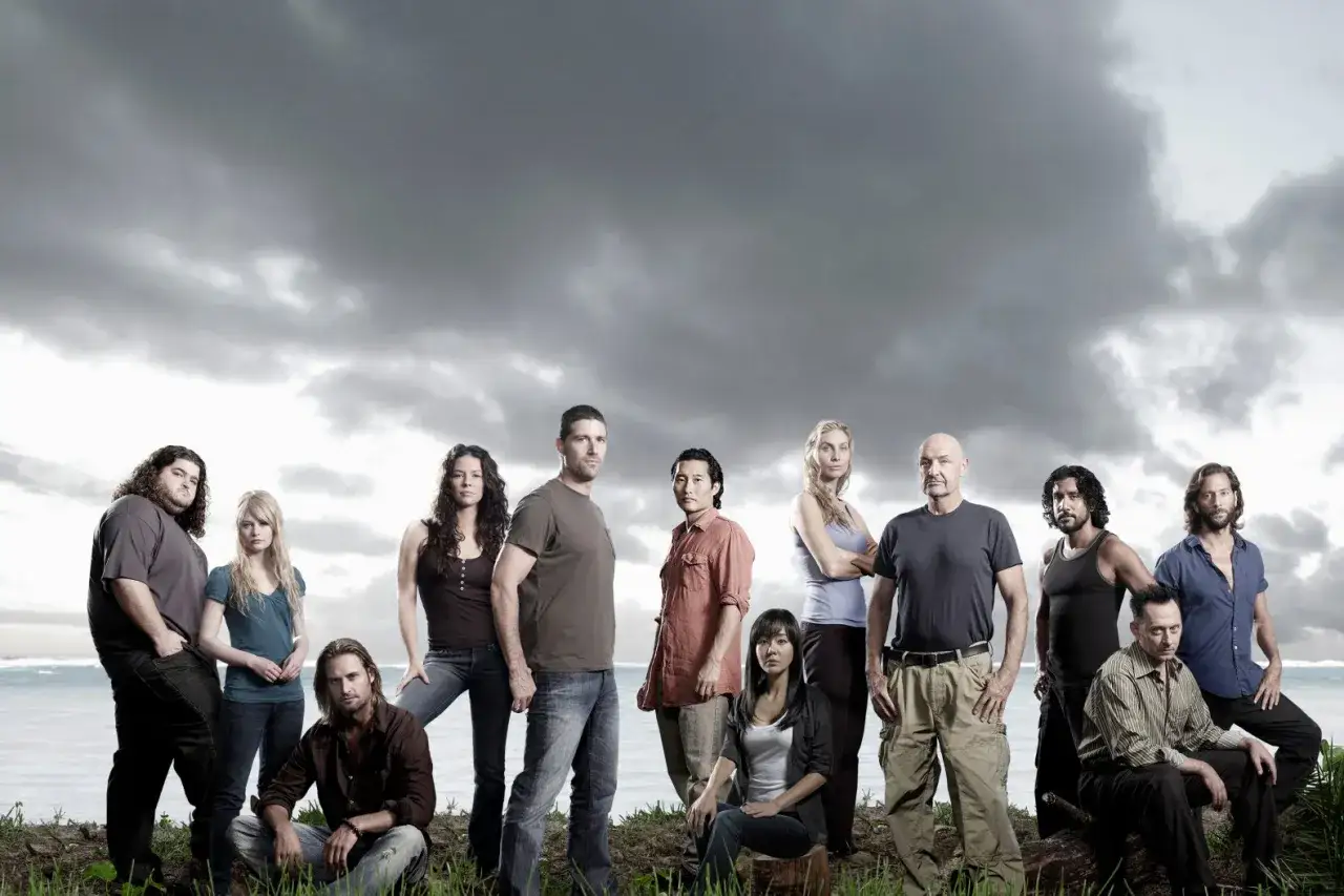 Die Hauptbesetzung von Lost steht vor einer dramatischen Wolkenkulisse am Strand.