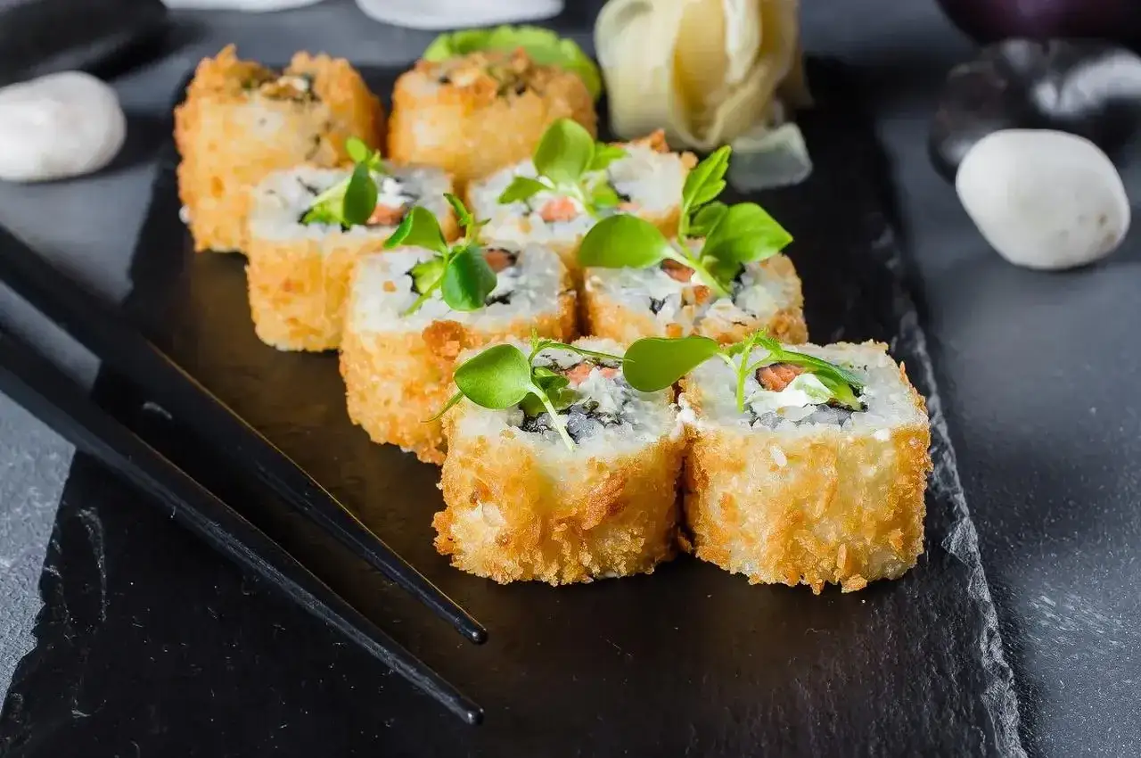 Chrupiące sushi w naleśniku, z łososiem i awokado, ozdobione zielonymi kiełkami. Idealna nazwa dla tego dania to 