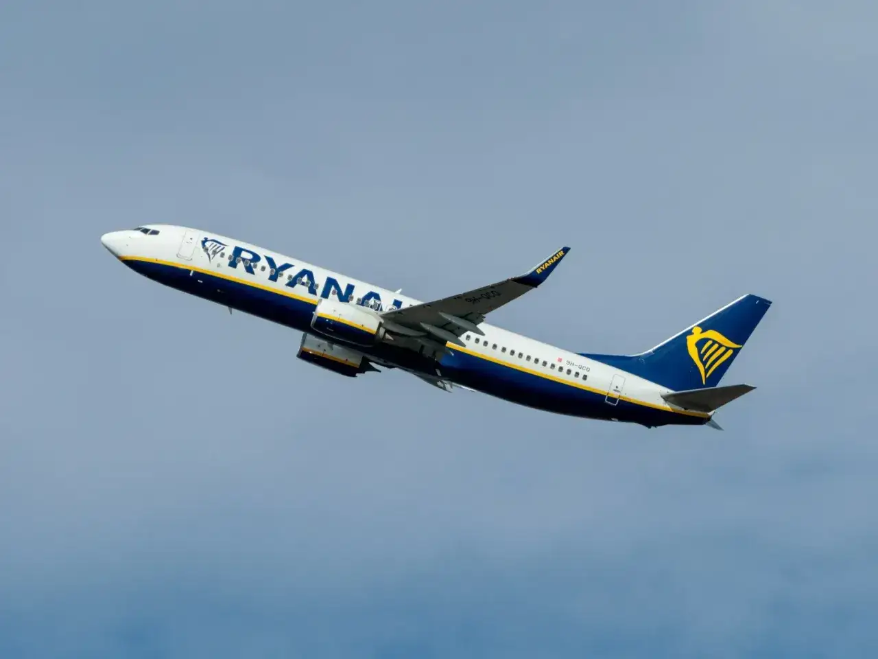 Samolot Ryanair wznosi się na tle błękitnego nieba. Zastanawiasz się, ile trwa lot do Londynu z Katowic?