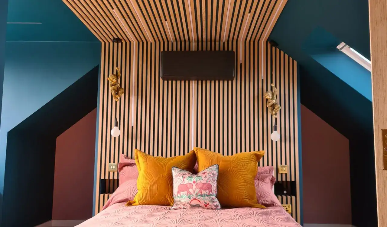 Tête de lit DIY unique avec lambris en bois, coussins colorés et singes décoratifs.