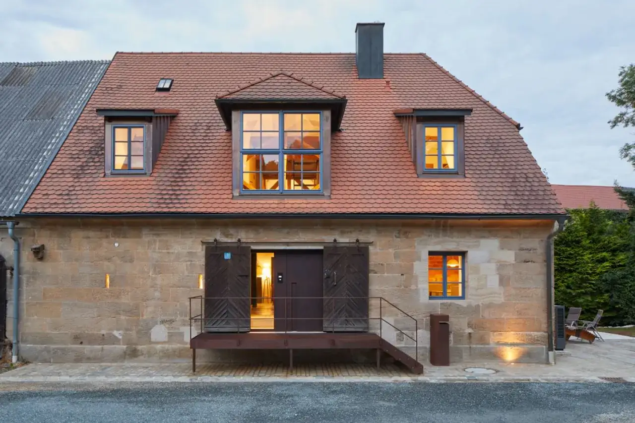 Moderne umgebaute Scheune mit rustikalen Holzt&uuml;ren und Fenstern. Tolle Ideen f&uuml;r Scheune umbauen!